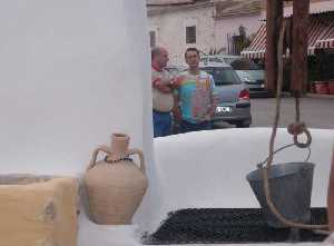 Dos hombres conversan junto al pozo 